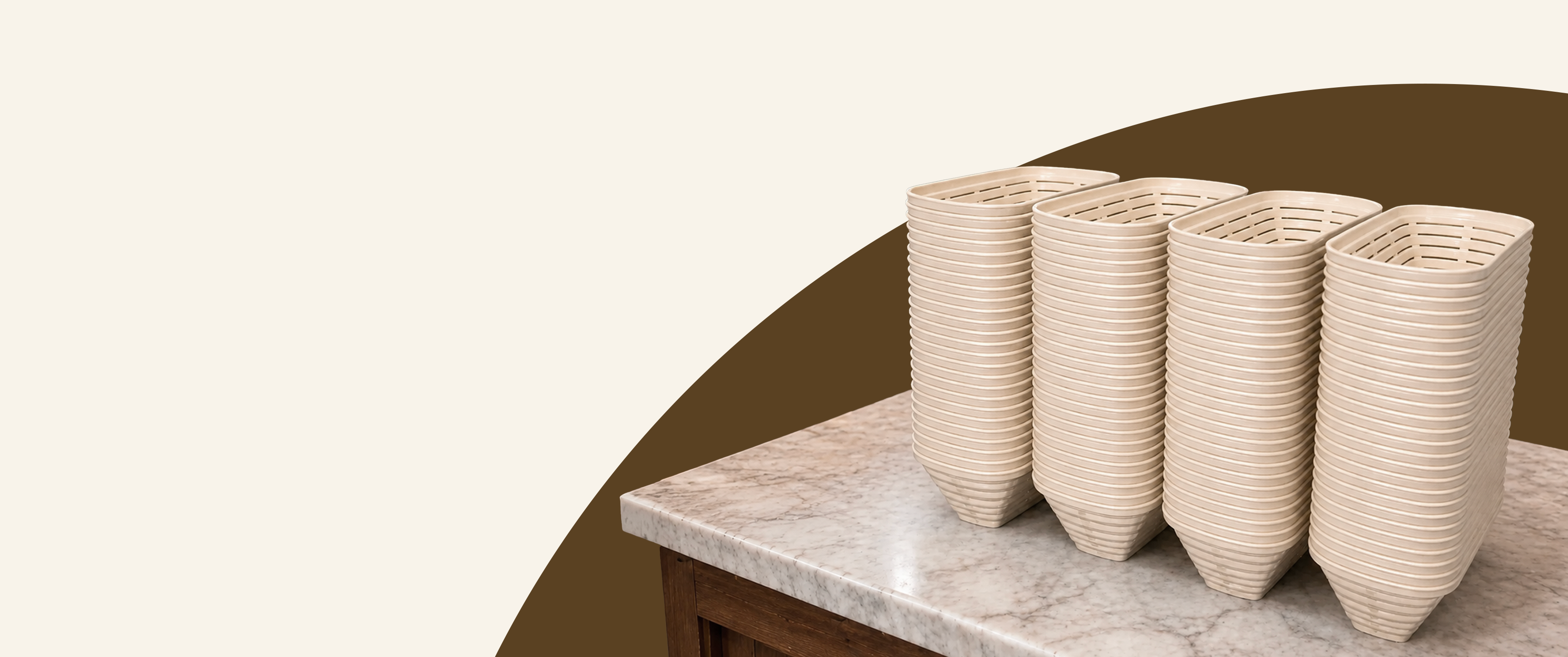 Set of woven baskets on a marble surface with a brown circular accent